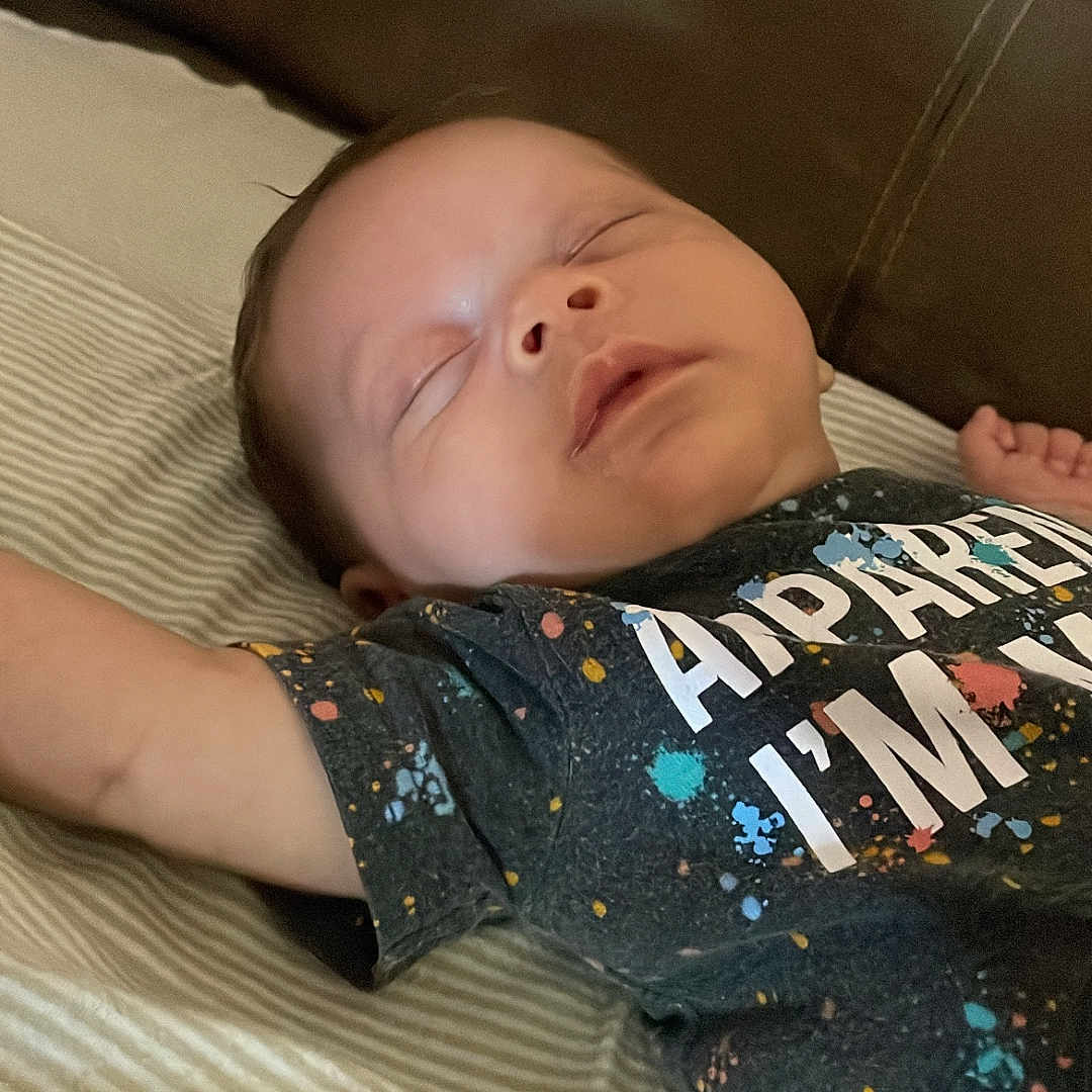 Zaydyn joined the competition — help win amazing prizes! arm, baby, bed, child, childhood, colorful, cute, face, indoors, infant, lying_down, peaceful, person, portrait, rest, sleep, sleeping, striped_sheet, tshirt, young