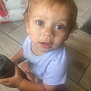 Zaydyn joined the competition — help win amazing prizes! toddler, child, baby, person, face, eyes, hair, clothing, floor, tile, hand, object, indoor, curious, sitting, looking_up, skin, young, essential_puffs, package