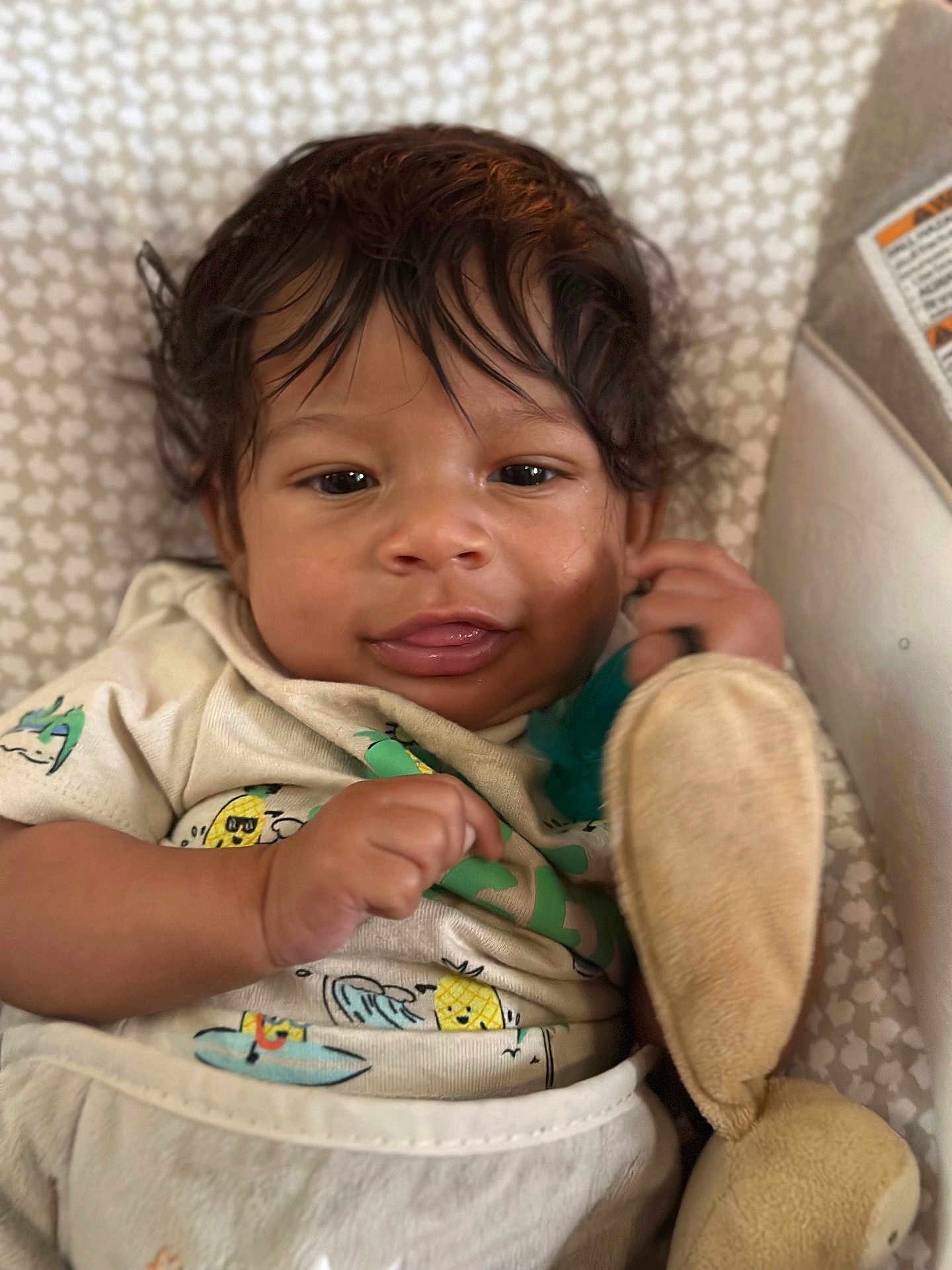 Malcolm Jr joined the competition — help win amazing prizes! baby, infant, child, plush_toy, soft_toy, cute, curly_hair, patterned_background, close_up, indoors, clothing, smiling, face, hand, sitting, person, young_child, portrait, cozy, toy