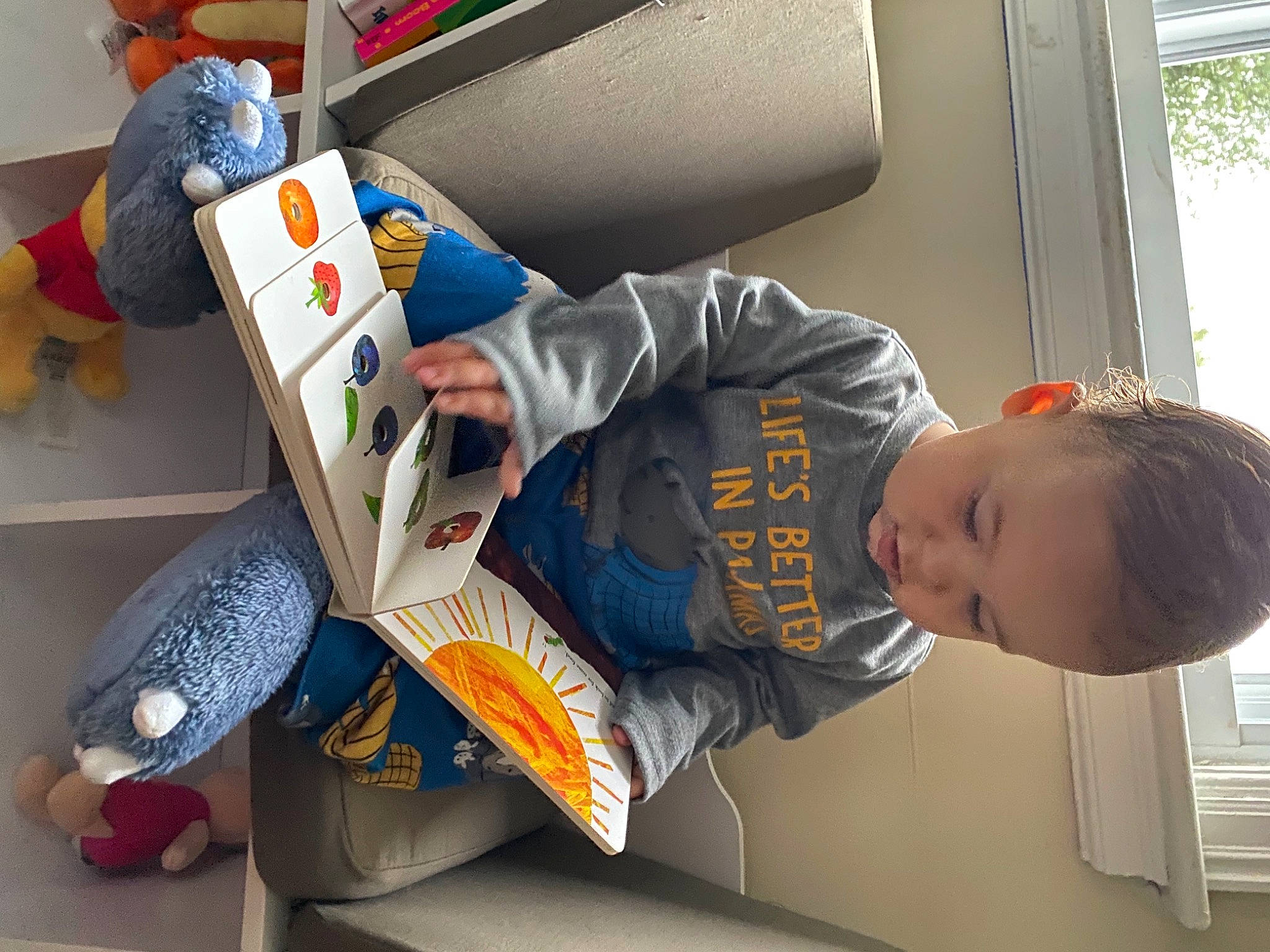 Noah is registered to the contest to win money with this photo: carmine, child, comfort, flooring, fun, lap, leisure, person, play, reading, room, sitting, sneakers, t_shirt, toddler, toy, transport, vacation