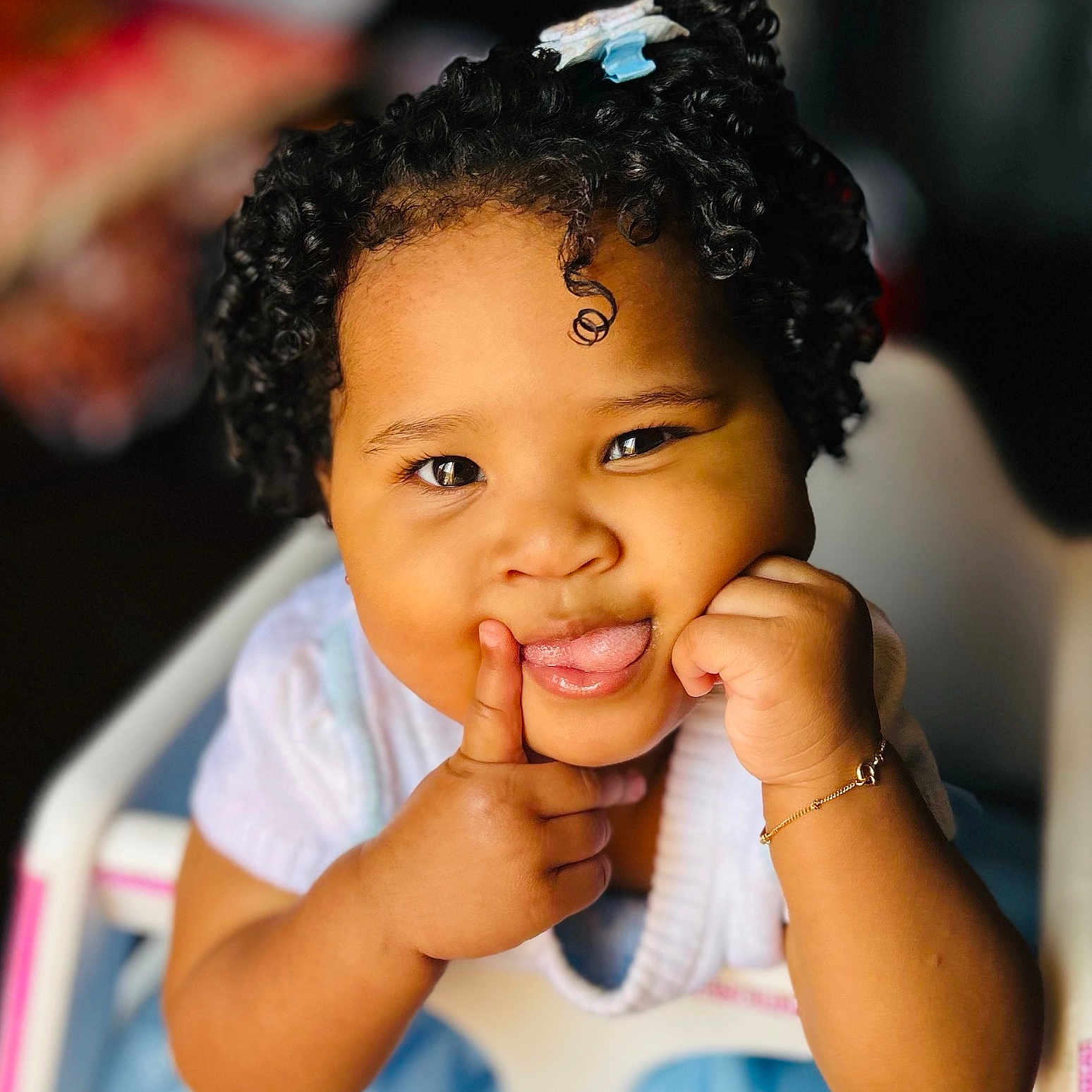 Kaymie is registered to the contest to win money with this photo: baby_clothes, bracelet, child, close_up, curly_hair, cute, expression, face, hand, happy, high_chair, indoors, person, playful, portrait, sitting, skin, smiling, toddler, tongue_out