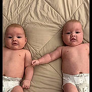 Rainin And River is registered to the contest to win money with this photo: baby, infant, diaper, bed, blanket, cute, child, holding_hands, lying_down, two_babies, skin, sleepwear, bedroom, comfort, twin_babies, newborn, naked_torso, soft, adorable, resting