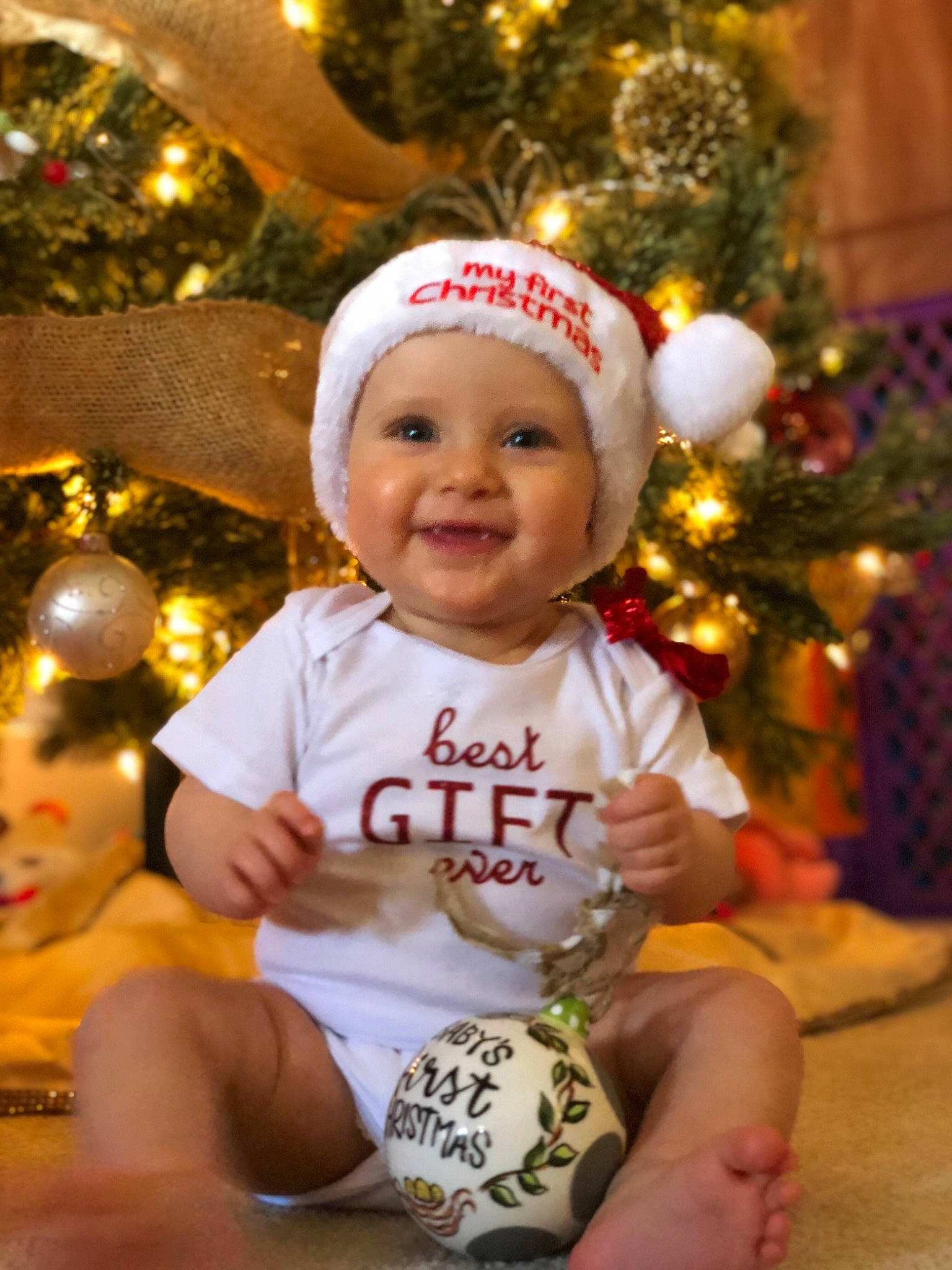 Kinsley joined the competition — help win amazing prizes! baby, child, christmas, christmas_decoration, christmas_eve, christmas_lights, christmas_ornament, christmas_tree, event, fun, happy, headwear, holiday, interior_design, joy, person, smile, toddler, tree