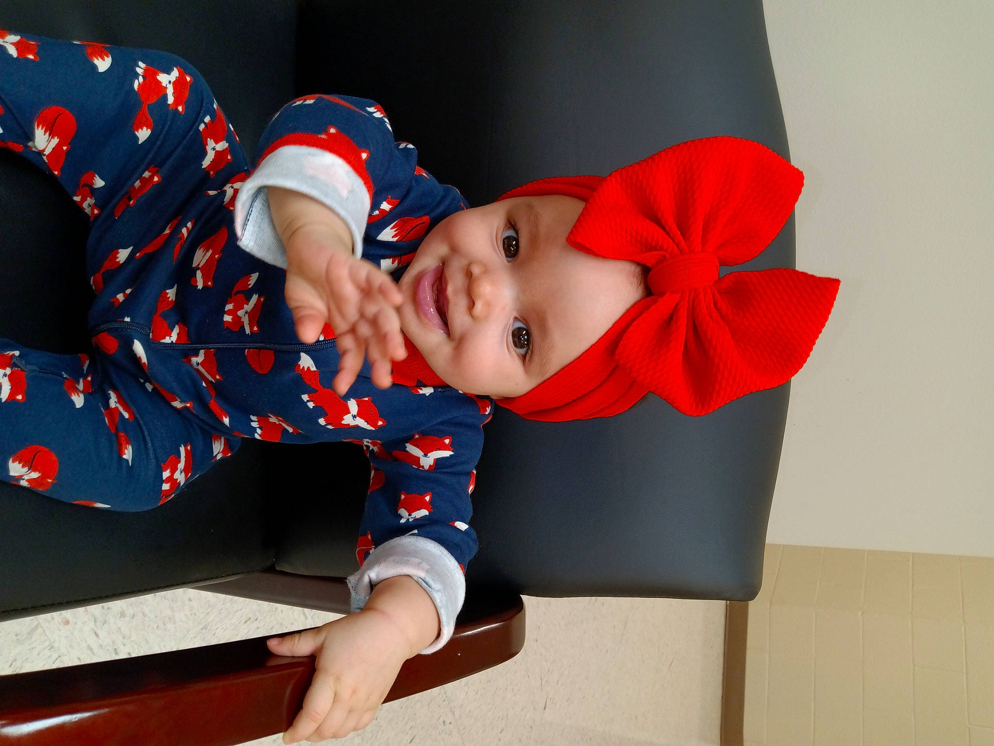 Kyndall is registered to the contest to win money with this photo: arm, baby, baby_toddler_clothing, carmine, child, collar, comfort, costume_hat, elbow, electric_blue, happy, hat, headgear, headwear, joy, pattern, person, sitting, sleeve, smile