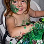 Willow is registered to the contest to win money with this photo: art_activity, bare_chested, child, childhood, creative, face_paint, fun, green_paint, happy, high_chair, indoor, mess, messy, paint_brush, paint_jars, playful, red_hair, smiling, table, toddler