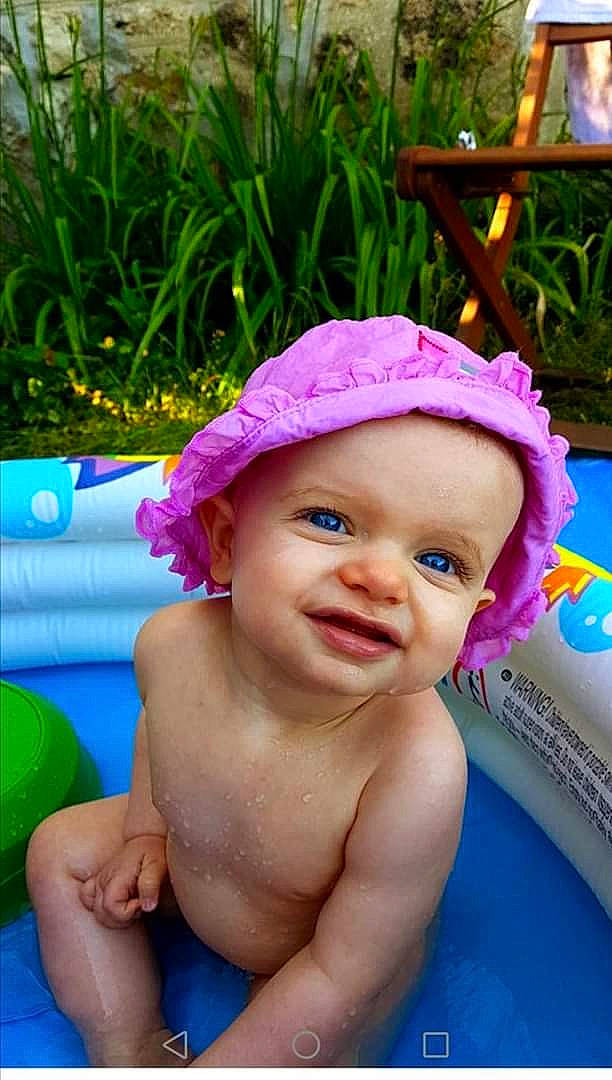 Lya a rejoint le concours — aidez-le/la à gagner de superbes lots ! baby_bathing, blue, cap, grass, green, happy, head, headgear, headwear, leisure, person, photograph, pink, plant, product, purple, skin, smile, summer, toddler