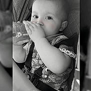 Tiziano participe au concours pour gagner de l'argent avec cette photo : baby, beads, bottle, car_seat, child, closeup, clothing, cute, drink, face, hand, indoors, infant, monochrome, person, portrait, seatbelt, sitting, toy, young_child