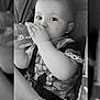 baby, beads, bottle, car_seat, child, closeup, clothing, cute, drink, face, hand, indoors, infant, monochrome, person, portrait, seatbelt, sitting, toy, young_child