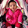 Bella is registered to the contest to win money with this photo: baby, child, pink_jacket, mittens, car_seat, patterned_fabric, winter_clothing, cute, infant, warm, hood, seat_belt, indoor, portrait, clothing, person, face, cozy, small_child, expression