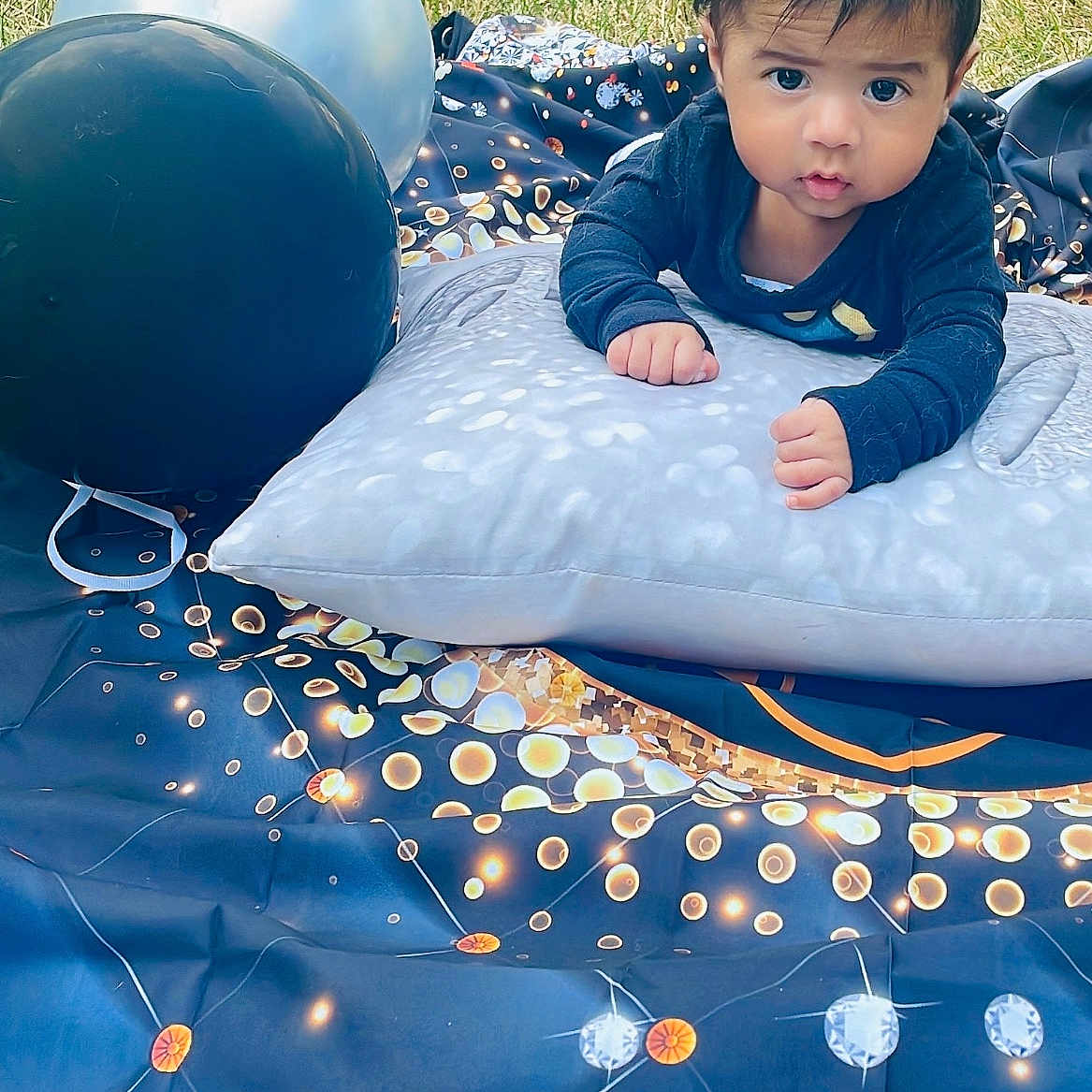 Thiago joined the competition — help win amazing prizes! baby, balloon, black, blanket, blue, child, clothing, curious, face, grass, infant, orange, outdoor, pattern, photography, pillow, portrait, star_pattern, white, young_child