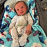 baby, infant, blanket, onesie, blue, cartoon, floral, cute, newborn, comfort, sleeping_bed, fabric, child, soft, hand, footed_pajamas, face, portrait, indoor, cozy