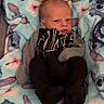 baby, infant, blanket, plush_toy, moon, star, clothing, face, expression, indoor, person, portrait, newborn, cute, sleeping_bag, soft_toys, baby_bed, cozy, lying_down, serious_face