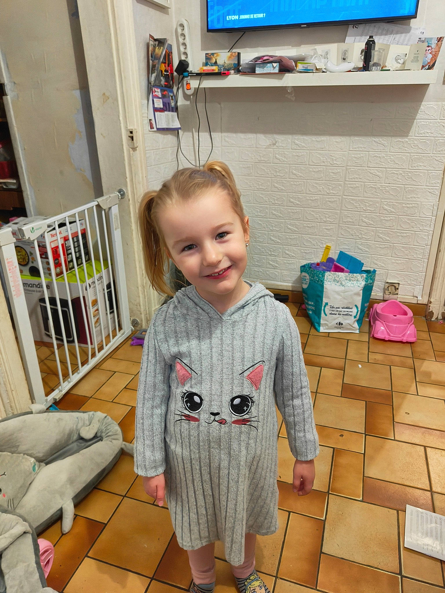 Lena a rejoint le concours — aidez-le/la à gagner de superbes lots ! baby, baby_toddler_clothing, bookcase, child, display_device, floor, flooring, fun, hardwood, joy, pattern, people, person, play, room, smile, standing, t_shirt, television, television_set