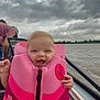 baby, life_jacket, water, boat, sky, clouds, hand, person, outdoor, smile, child, happy, transport, nature, people, watercraft, safety, pink, adult, daytime