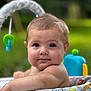 baby, infant, child, playpen, colorful, animal_prints, outdoor, green_background, face, arms, cute, portrait, soft_focus, toys, play, young, skin, head, expression, calm