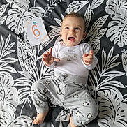 Adam participe au concours pour gagner de l'argent avec cette photo : baby, infant, smiling, lying_down, blanket, patterned_blanket, penguin_pants, white_shirt, happy, child, six_months, card, indoors, cute, person, small_child, toddler, clothing, face, hands