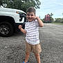 Matthew joined the competition — help win amazing prizes! child, boy, smiling, pose, shorts, striped_shirt, sneakers, outdoor, road, truck, vehicle, trees, sky, fence, playful, happy, casual_clothing, daytime, person, nature