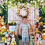 child, boy, smiling, easter, bunny, flower_pot, flowers, wreath, garden, decorations, wooden_door, greenery, holiday, spring, cute, portrait, indoor, colorful, playful, festive