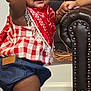 Layla is registered to the contest to win money with this photo: toddler, child, red_bow, bandana, plaid_shirt, denim_shorts, barefoot, wooden_floor, leather_chair, studs, indoor, portrait, cute, smiling, person, baby, standing, home, decor, hand
