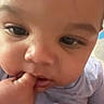Jamaree is registered to the contest to win money with this photo: baby, close_up, face, fingers, hand, chubby_cheeks, curious, infant, skin, child, person, portrait, cute, young, expression, wearing, clothing, indoors, soft_lighting, nibbling