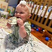 Evalynn joined the competition — help win amazing prizes! baby, child, infant, dress, headband, flower, chewing, card, blanket, nursery, crib, toy, floor, happy, sitting, indoors, cute, smiling, person, young