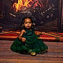 child, clothing, couch, dress, face, female, fireplace, footwear, formalwear, furniture, girl, hardwood, head, indoors, person, photography, portrait, sitting, toy, wood