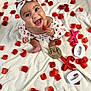 Gianna joined the competition — help win amazing prizes! baby, infant, headband, red_hearts, white_blanket, rose_petals, smiling, happy, six_months, wooden_letters, xoxo, cute, sitting, clothing, face, hand, feet, portrait, decor, celebration