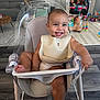baby, high_chair, bib, smile, happy, toys, living_room, floor_lamp, fireplace, plush_toy, carpet, footrest, child, furniture, indoor, person, seat, modern, play_area, wood_floor