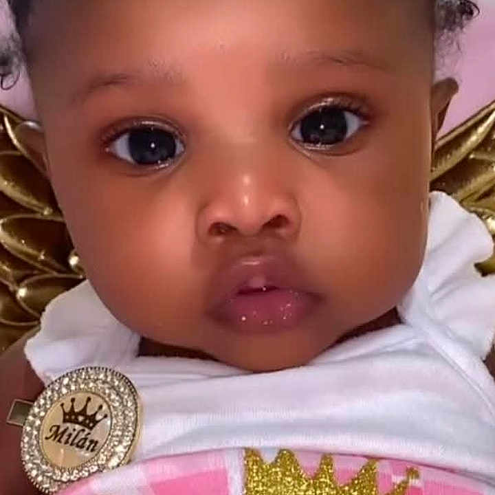 Mailan is registered to the contest to win money with this photo: baby, badge, cheeks, child, close_up, clothing, crown, cute, expression, eyes, face, girl, glitter, gold, infant, pink, portrait, soft_background, sparkle, white_outfit