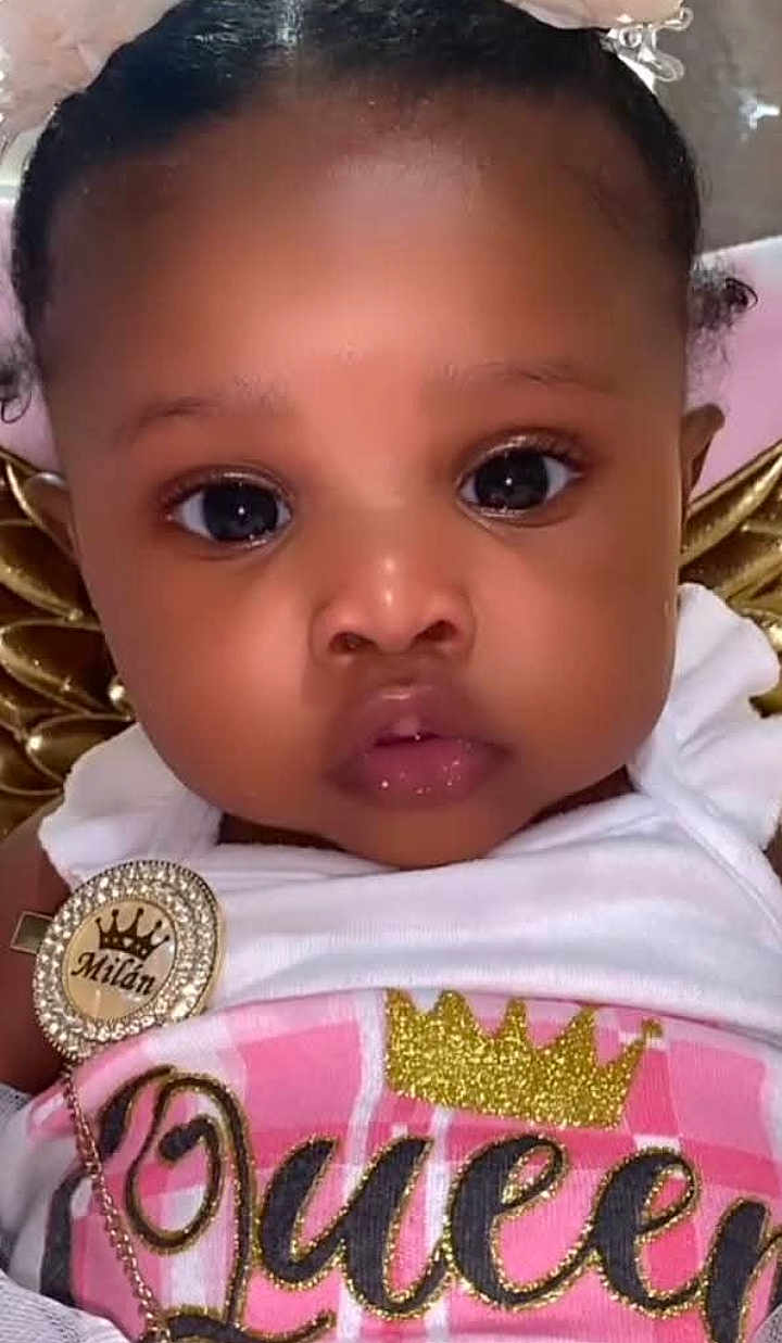 Mailan is registered to the contest to win money with this photo: baby, child, face, portrait, close_up, cute, infant, girl, clothing, white_outfit, glitter, gold, crown, badge, sparkle, pink, eyes, cheeks, expression, soft_background