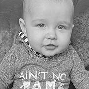 Callum is registered to the contest to win money with this photo: baby, infant, child, portrait, black_and_white, sweater, clothing, couch, leather, face, eyes, hair, mouth, sitting, cute, indoors, expression, person, young, cozy
