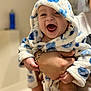 baby, child, smiling, happy, hooded_robe, blue, white, polka_dots, hand, bracelet, indoor, person, portrait, cute, infant, laughing, clothing, warm, soft, holding