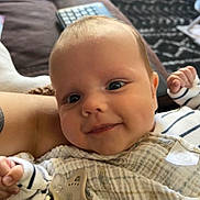 Harry joined the competition — help win amazing prizes! baby, infant, smile, face, blanket, pacifier, striped_clothing, hand, couch, carpet, indoor, person, cute, child, young, portrait, cozy, home, comfort, expression