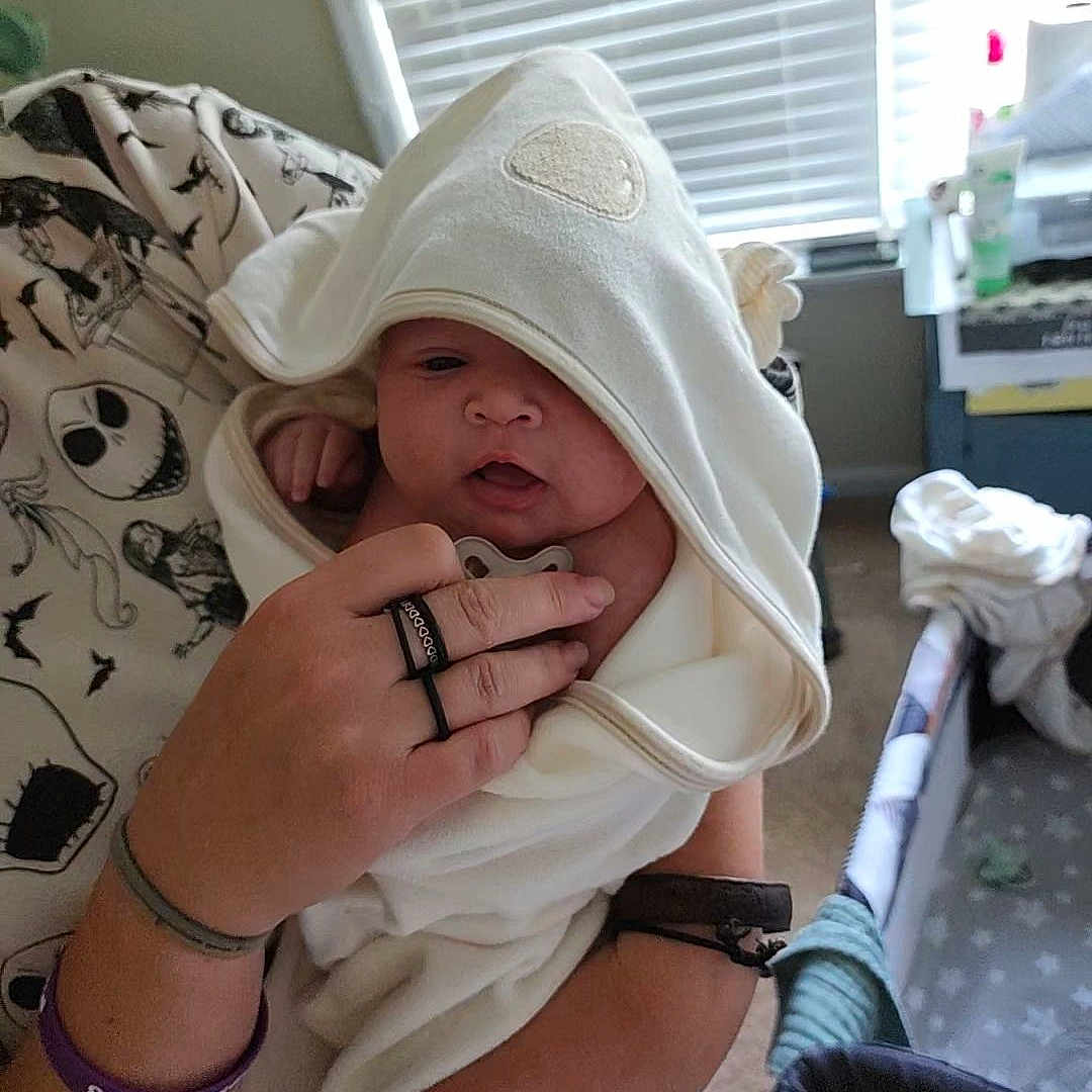 Kalista joined the competition — help win amazing prizes! adult, baby, bedroom, blanket, bracelet, clothing, curious, face, hand, holding, hooded_towel, indoor, infant, pacifier, person, ring, skin, soft_lighting, towel, window_blinds