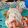 baby, smiling, infant, play_mat, onesie, floral_pattern, cartoon, sea_creatures, indoor, child, cute, happy, lying_down, colorful, toy, fun, small_child, cheerful, person, baby_girl