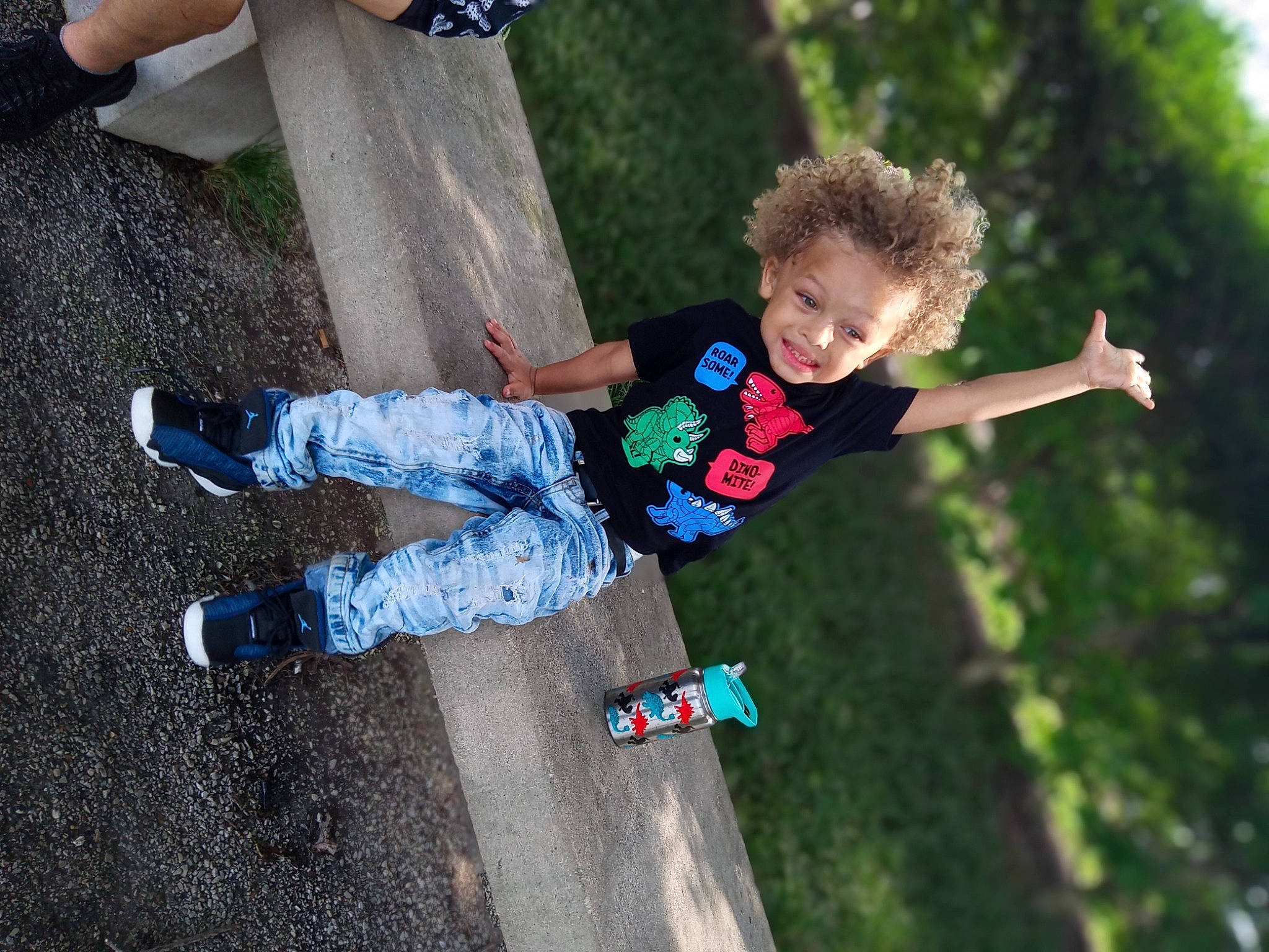 Brent is registered to the contest to win money with this photo: asphalt, child, city, denim, elbow, electric_blue, fun, gesture, grass, happy, human_leg, leisure, people_in_nature, person, play, recreation, smile, sock, toddler, tree