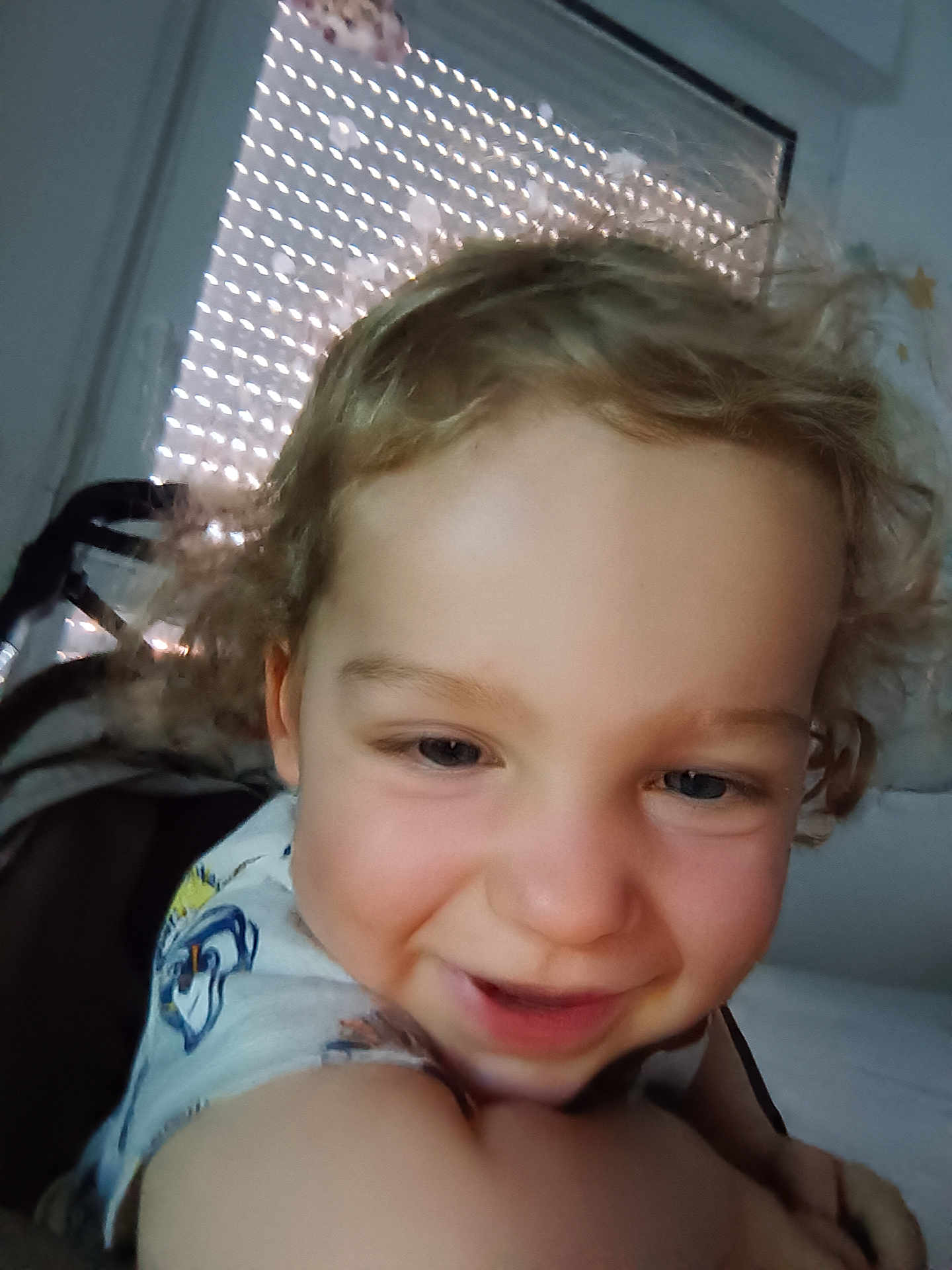 Hélyas participe au concours pour gagner de l'argent avec cette photo : arm, background, bedroom, blinds, casual_clothing, child, closeup, curly_hair, cute, face, happy, indoor, light_pattern, person, portrait, skin, smiling, toddler, window, young_child