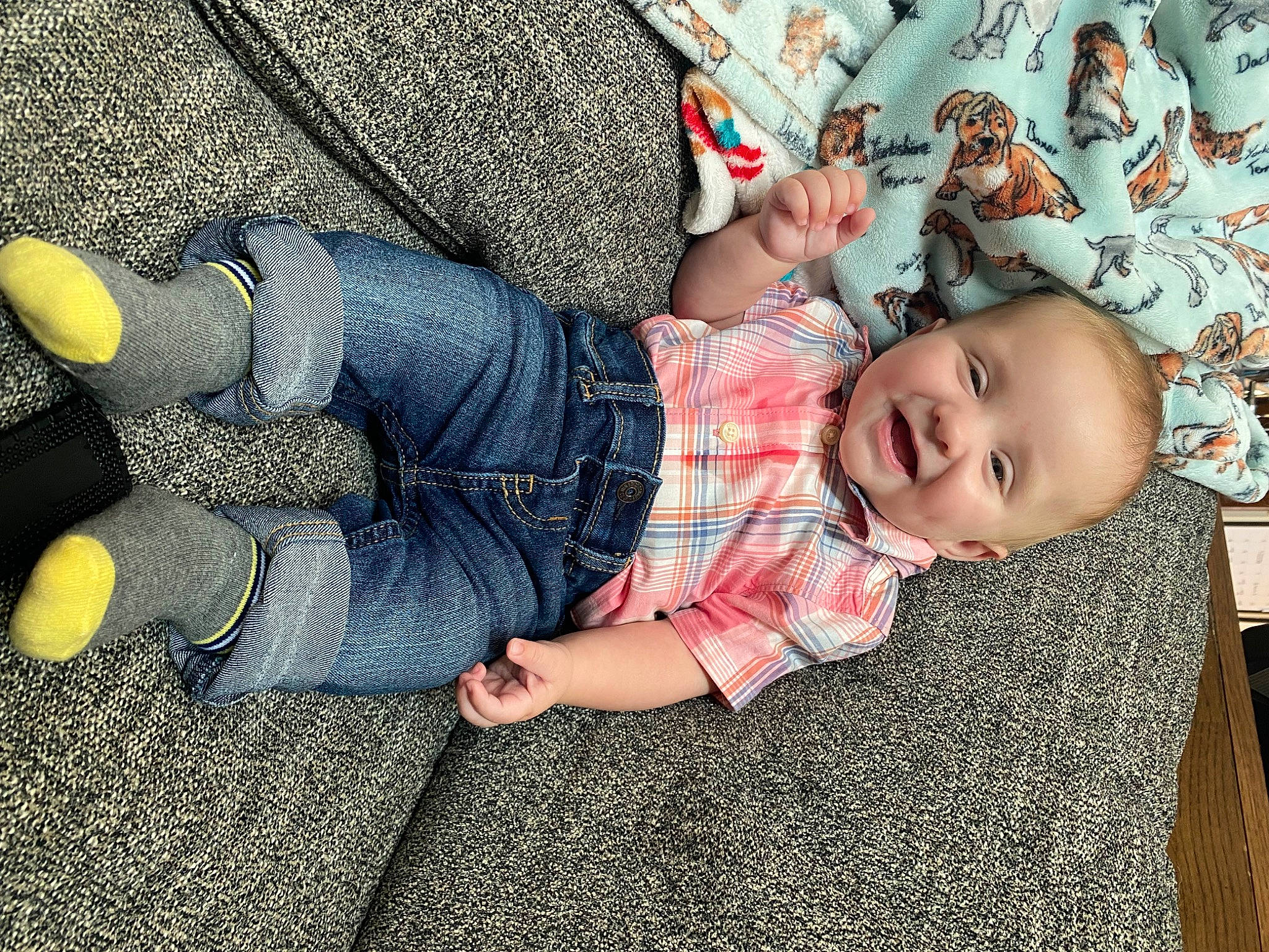 Conrad is registered to the contest to win money with this photo: baby, baby_toddler_clothing, comfort, denim, electric_blue, finger, flooring, foot, fun, gesture, human_leg, leaf, nail, pattern, person, sitting, smile, thigh, toddler, tree
