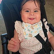 Laya Aurora joined the competition — help win amazing prizes! baby, child, smile, tongue_out, stroller, bib, clothing, face, hair, hand, safety_strap, seat, indoor, happy, cute, infant, person, portrait, young_child, playful