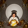 Laya Aurora is registered to the contest to win money with this photo: toddler, birthday_cake, candle, balloons, party, celebration, child, pigtails, shadow, spotlight, yellow, white, gold, decorations, cake_decorations, sitting, indoors, cute, happy, festive