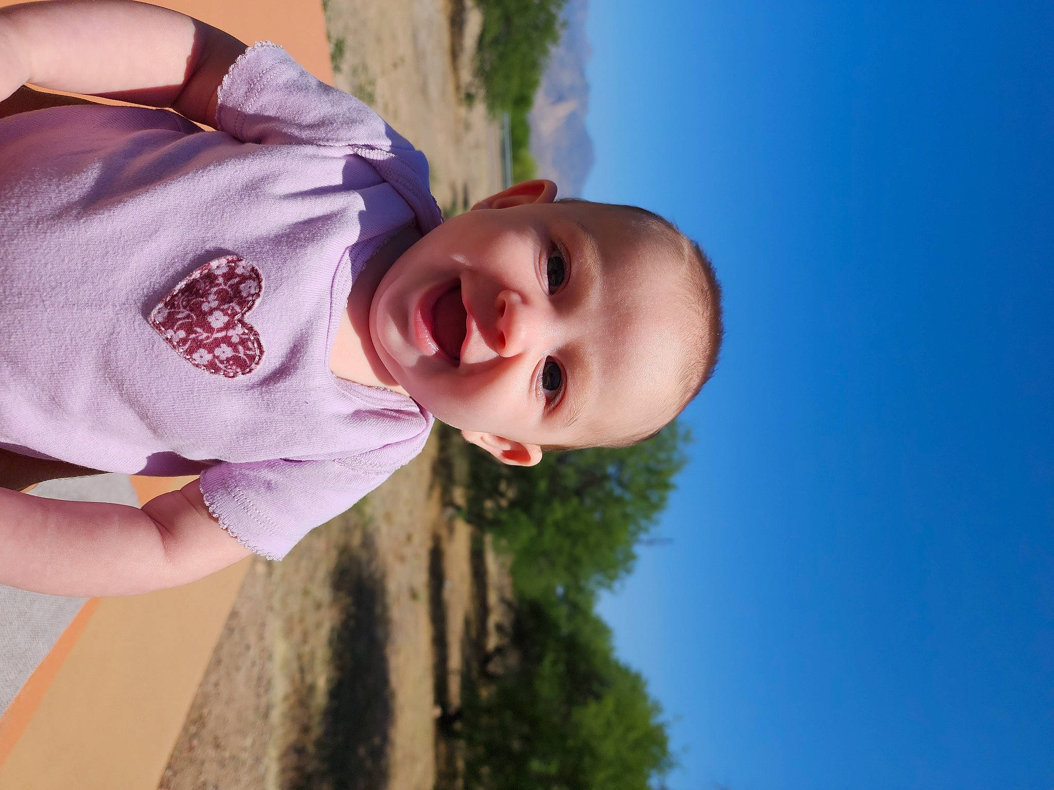 Sophiamarie is registered to the contest to win money with this photo: baby, child, flash_photography, fun, gesture, grass, grass_family, happy, leisure, nose, people_in_nature, person, plant, skin, sky, smile, standing, sunlight, toddler, tree