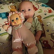 Daisy is registered to the contest to win money with this photo: baby, doll, pillow, animal_print, infant, child, toy, pink_clothing, sleepwear, face, eyes, lying_down, cute, soft_lighting, indoor, fabric, pattern, hand, head, comfort