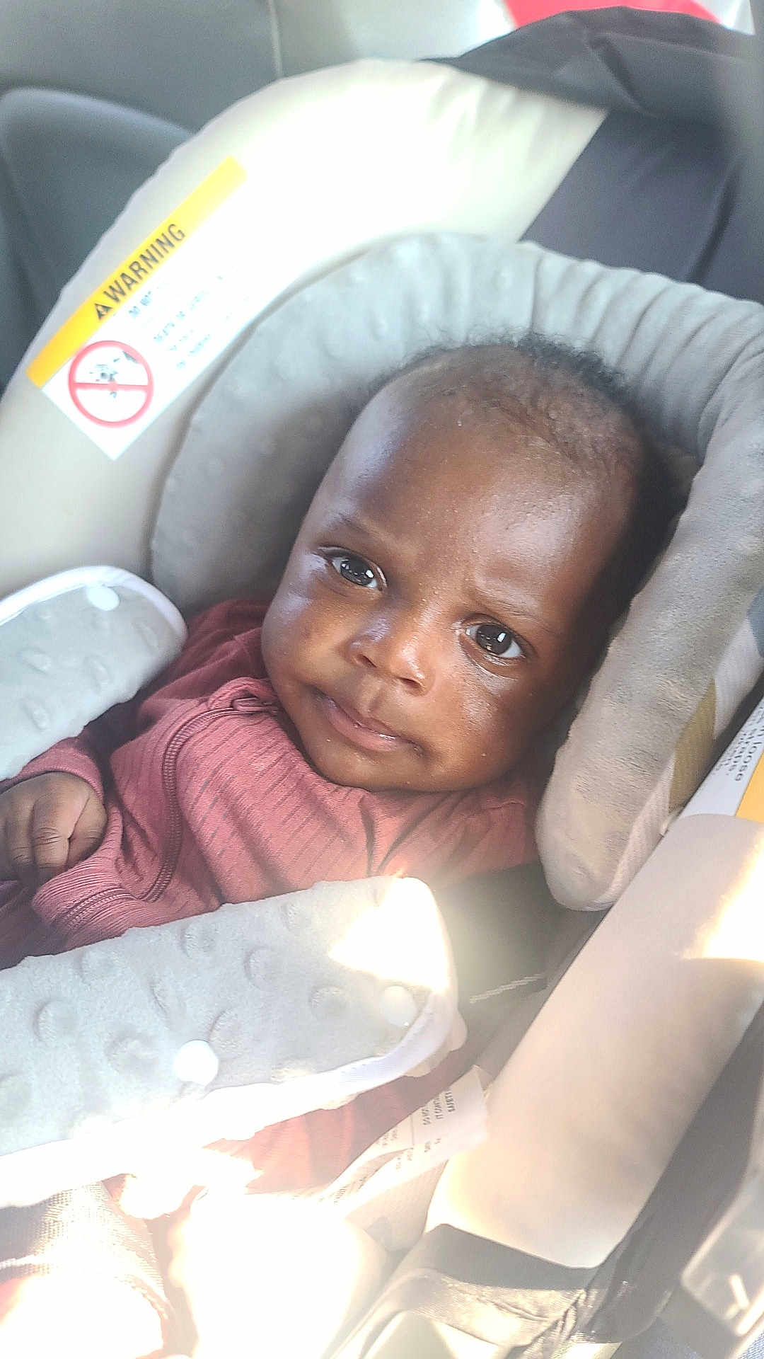 Kuot joined the competition — help win amazing prizes! baby, child, car_seat, seat_belt, clothing, infant, face, eyes, padded_strap, indoor, seat, head_support, safety, young_child, person, cute, looking_at_camera, casual, warm_light, portrait