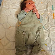 Eliasse participe au concours pour gagner de l'argent avec cette photo : baby, infant, clothing, overalls, socks, changing_pad, animal_prints, face, hand, footwear, fabric, bedroom, wall, soft_toys, pattern, cute, newborn, child, indoors, person