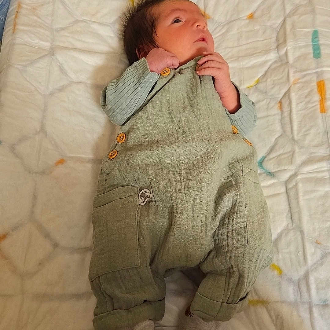 Eliasse participe au concours pour gagner de l'argent avec cette photo : animal_prints, baby, bedroom, changing_pad, child, clothing, cute, fabric, face, footwear, hand, indoors, infant, newborn, overalls, pattern, person, socks, soft_toys, wall