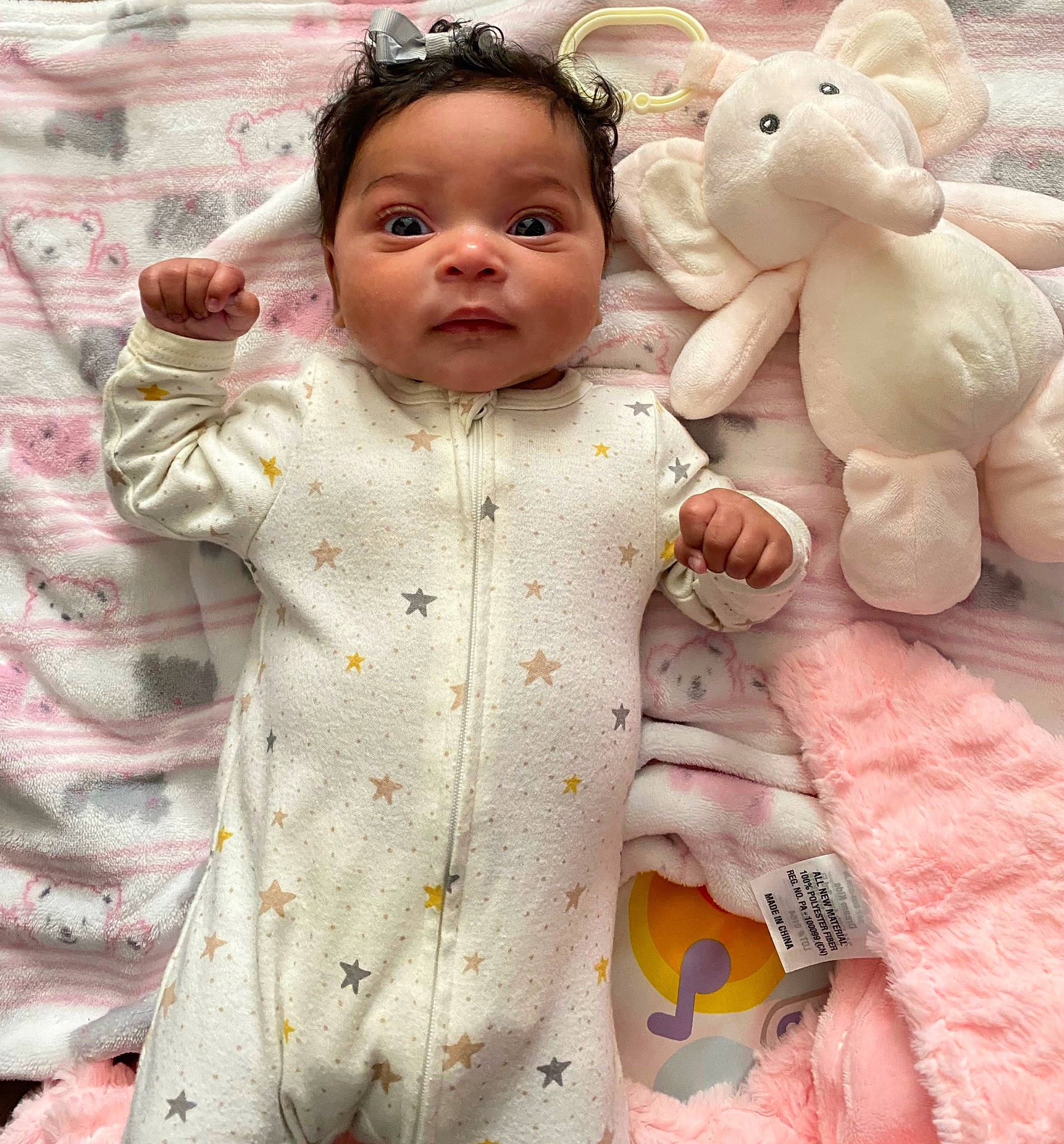 Kamora is registered to the contest to win money with this photo: arm, baby_toddler_clothing, cheek, child, doll, dress, eyelash, face, happy, head, nose, organ, outerwear, person, pink, skin, sleeve, stuffed_toy, textile, toy