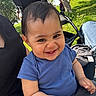 baby, blue_shirt, casual_clothing, child, cute, daylight, grass, greenery, happy, infant, joyful, nature, outdoor, park, person, portrait, smiling, stroller, sunlight, trees