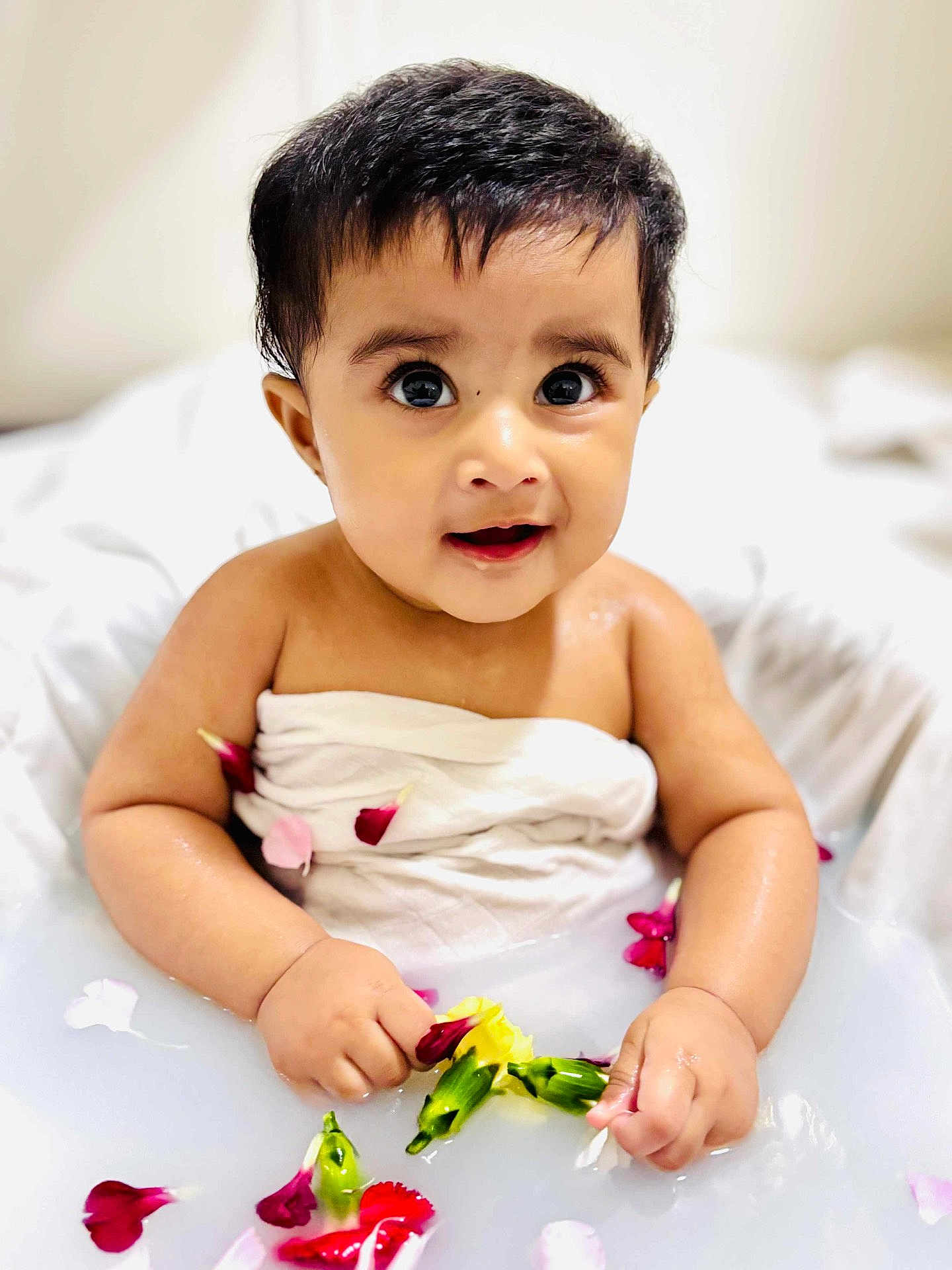 Meherish a rejoint le concours — aidez-le/la à gagner de superbes lots ! baby, bath_time, child, curious, cute, expression, face, flower_petals, hand, indoors, infant, milky_bath, portrait, sitting, skin, small_hands, water, wet, white_cloth, young_child