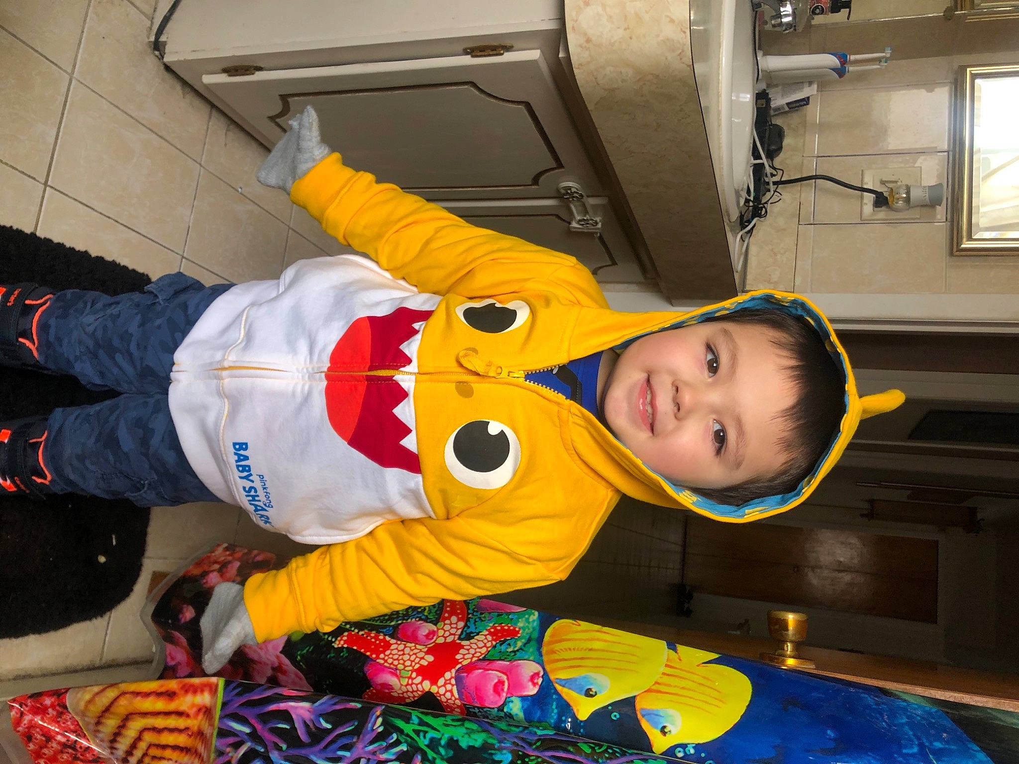 Christian is registered to the contest to win money with this photo: baby_toddler_clothing, child, cooking, event, flooring, fun, joy, machine, person, picture_frame, room, smile, t_shirt, toddler