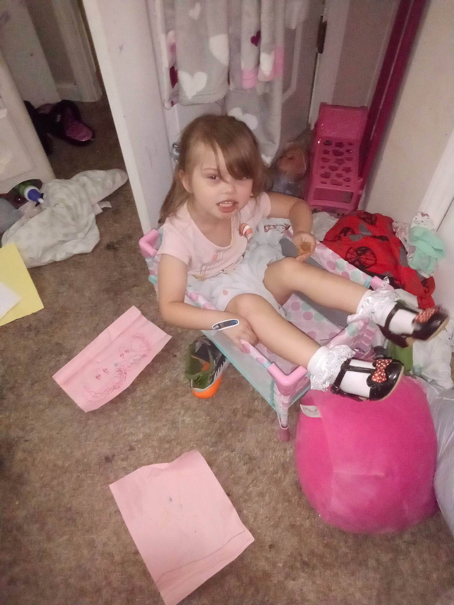 Delila joined the competition — help win amazing prizes! baby, child, dress, event, face, flooring, fun, human_body, human_leg, leg, magenta, person, pink, riding_toy, room, shorts, sitting, smile, sock, thigh